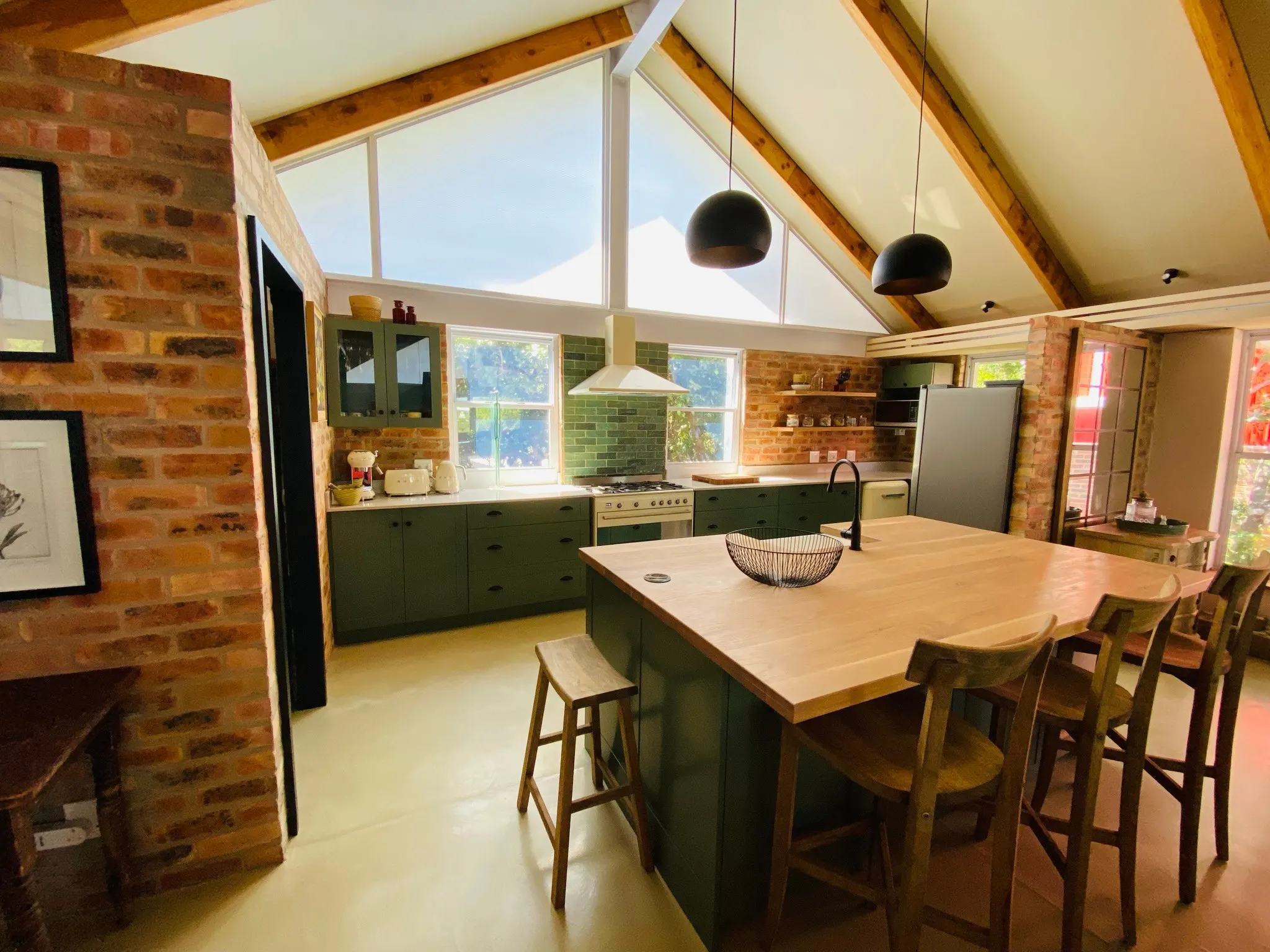 Pale stone alongside green cabinetry and exposed brick