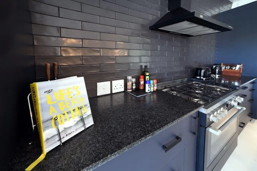 A dark polished counter against charcoal tiles
