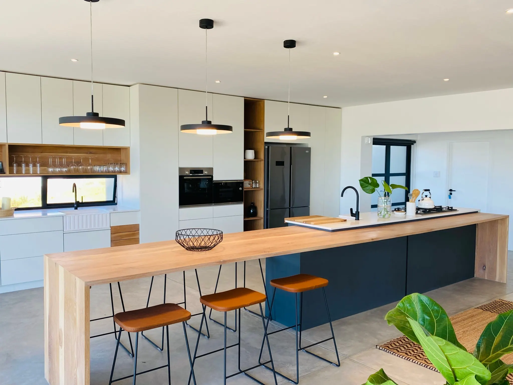 A stone island paired with timber and charcoal cabinetry