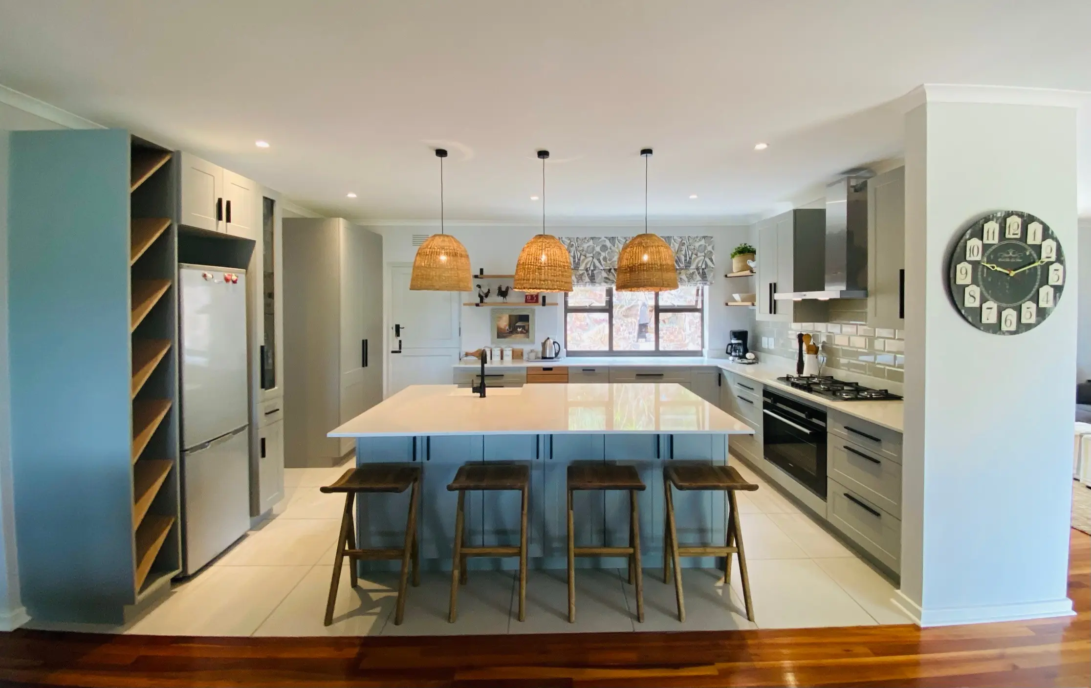 A pale stone island beneath woven pendant lights