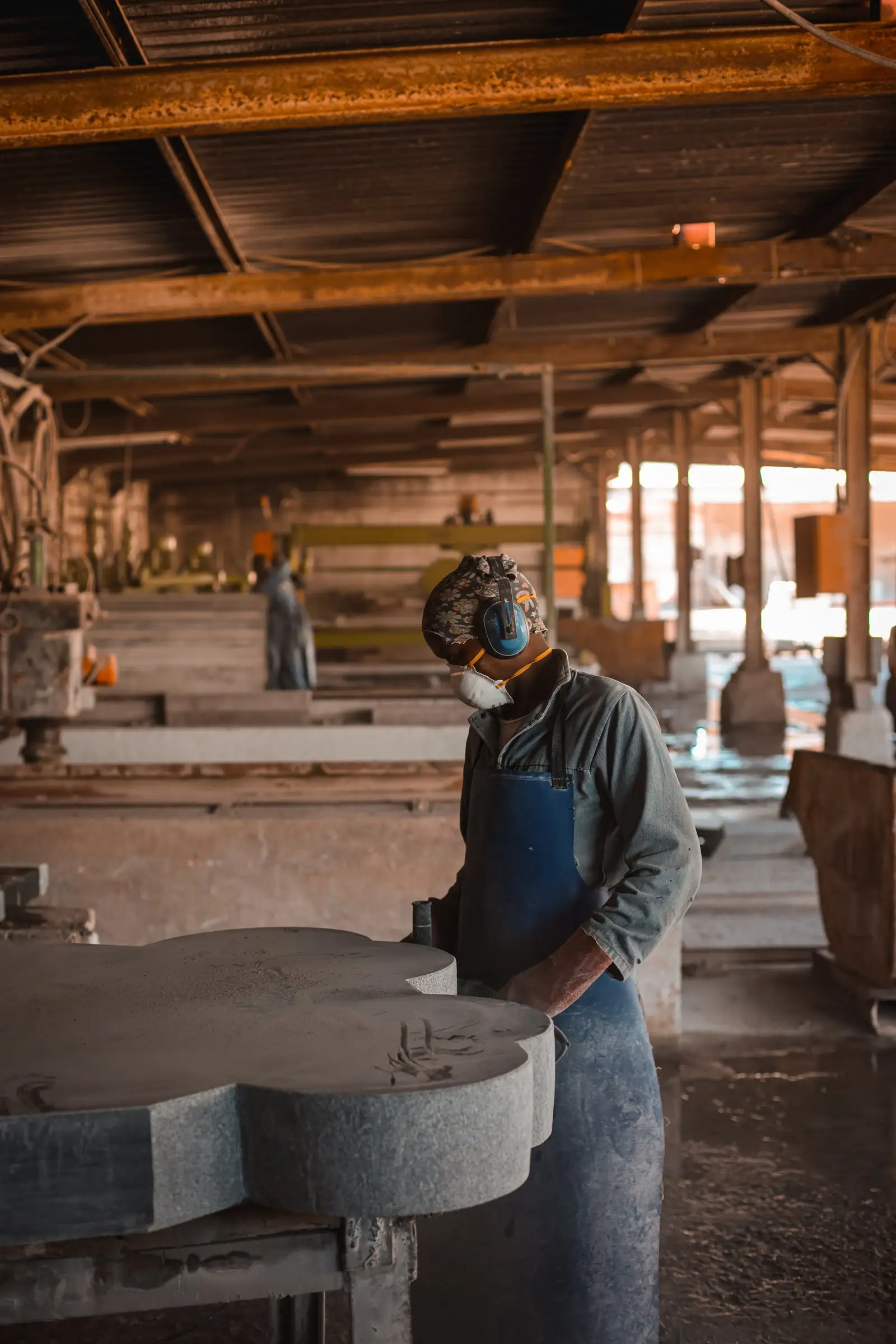 A CMG craftsperson shaping a granite memorial in the factory