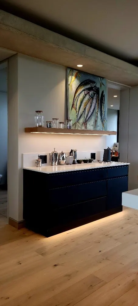 A dark stone vanity beneath a wide mirror